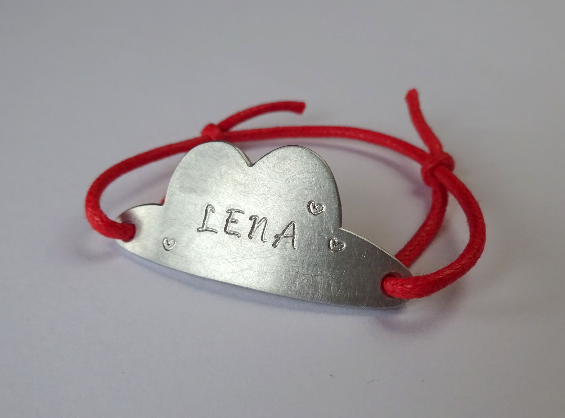 Telefoonnummer en naam armbandje voor kind met afbeelding van geboortekaartje.