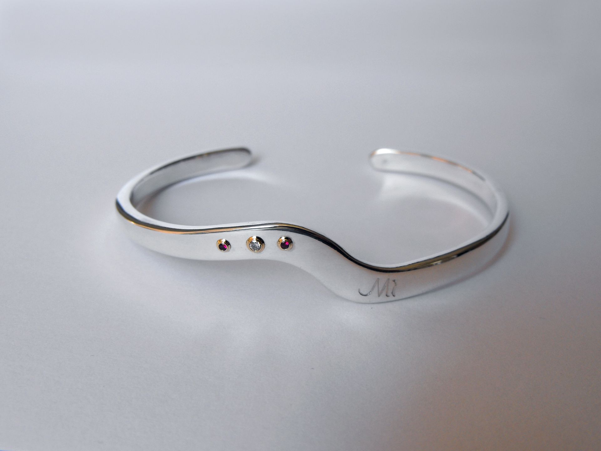 Zilveren spang armband met edelstenen en gravure.