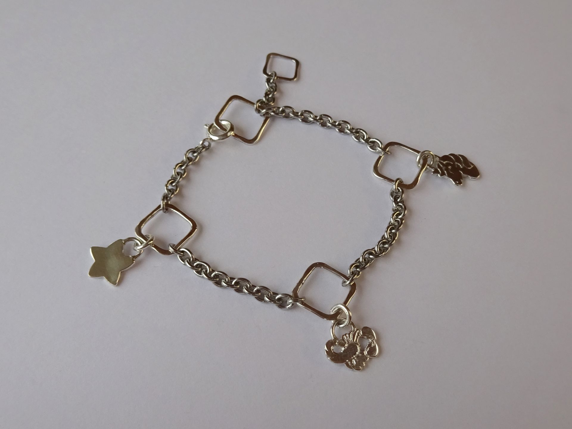 Zilveren kinder armbandje met bedeltjes van sterrenbeeld en andere persoonlijke bedels.