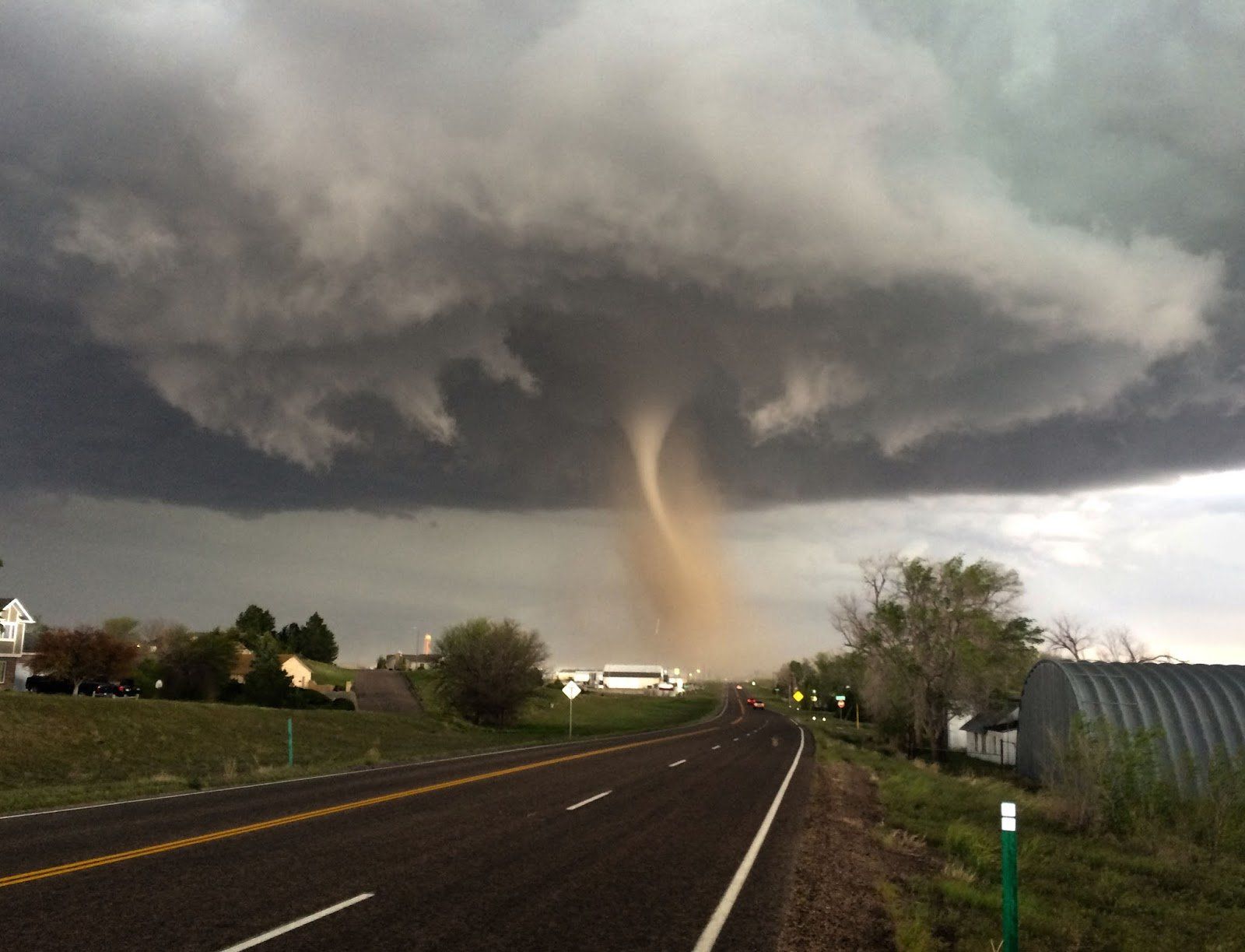 A tornado is coming down the road in the distance