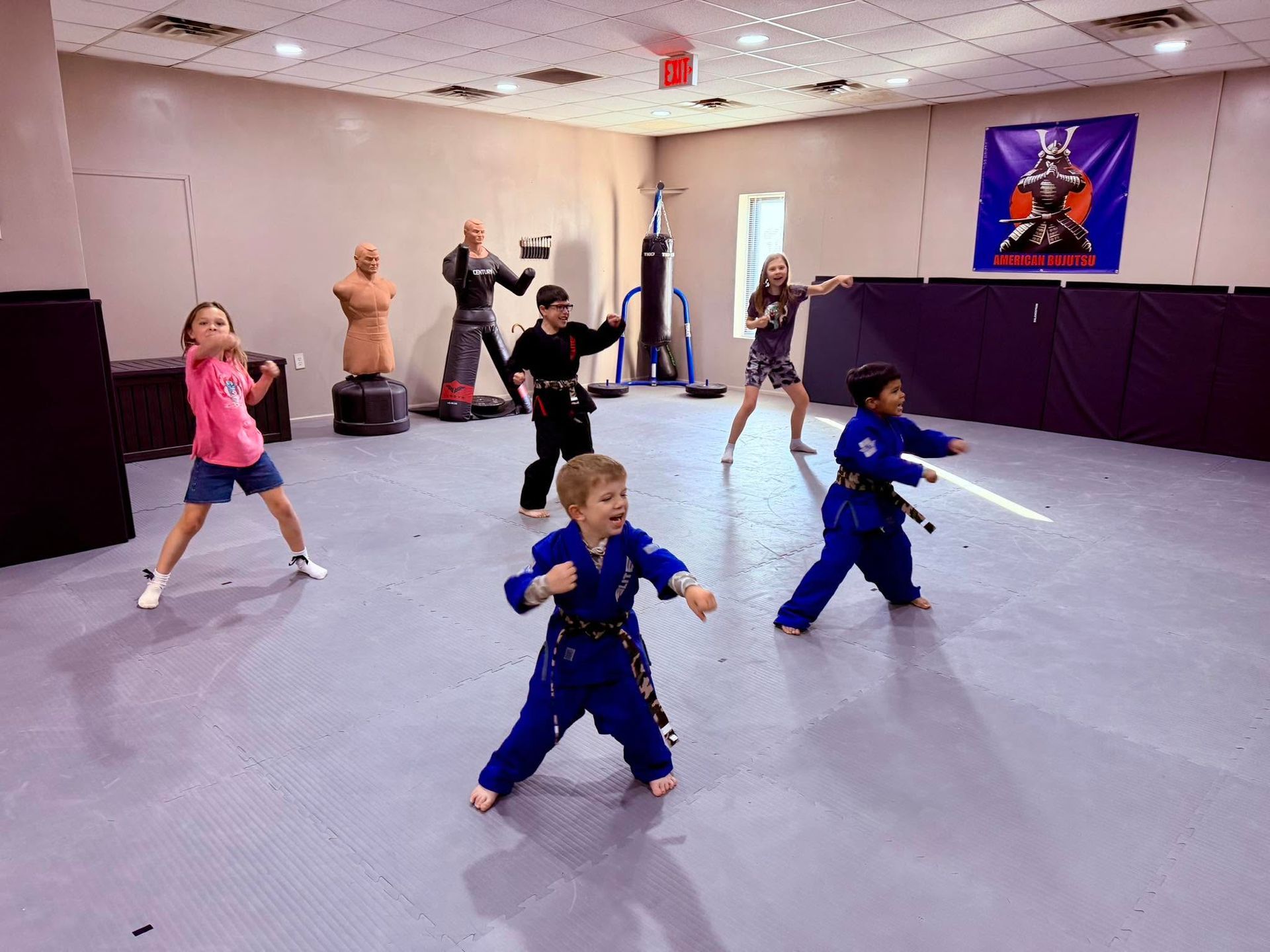 Children practicing martial arts in a studio, in colorful uniforms with kicking and punching poses.
