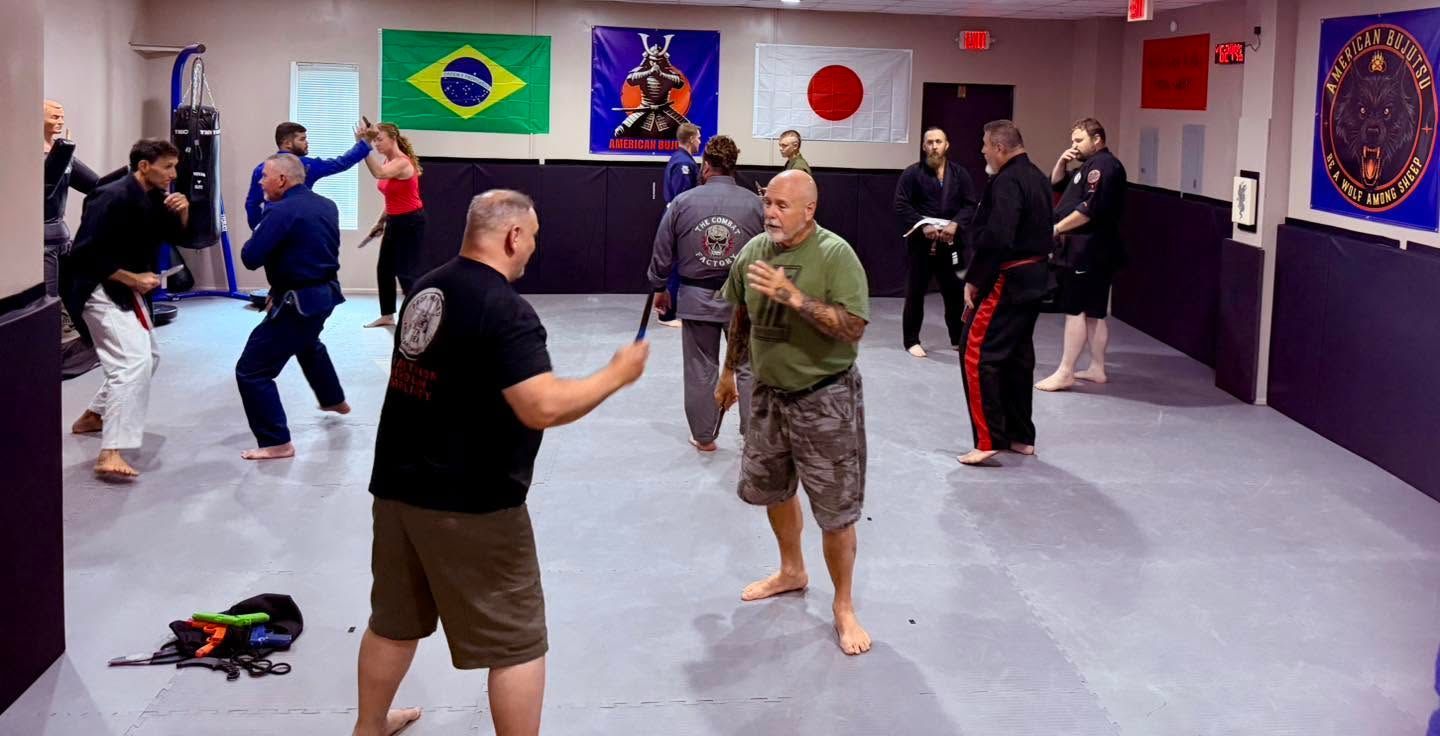 People practicing martial arts in a studio with mats and flags on the wall