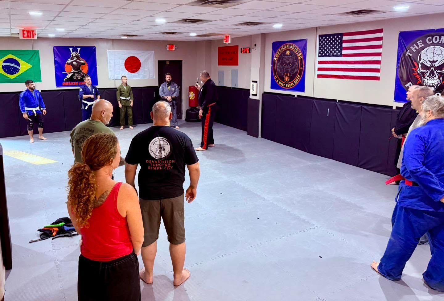 Martial arts class practicing in a mirrored dojo with flags on the walls