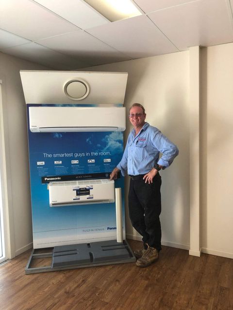 A Man Standing in Front of an Air Conditioner - Refrigeration Service in South Burnett, QLD