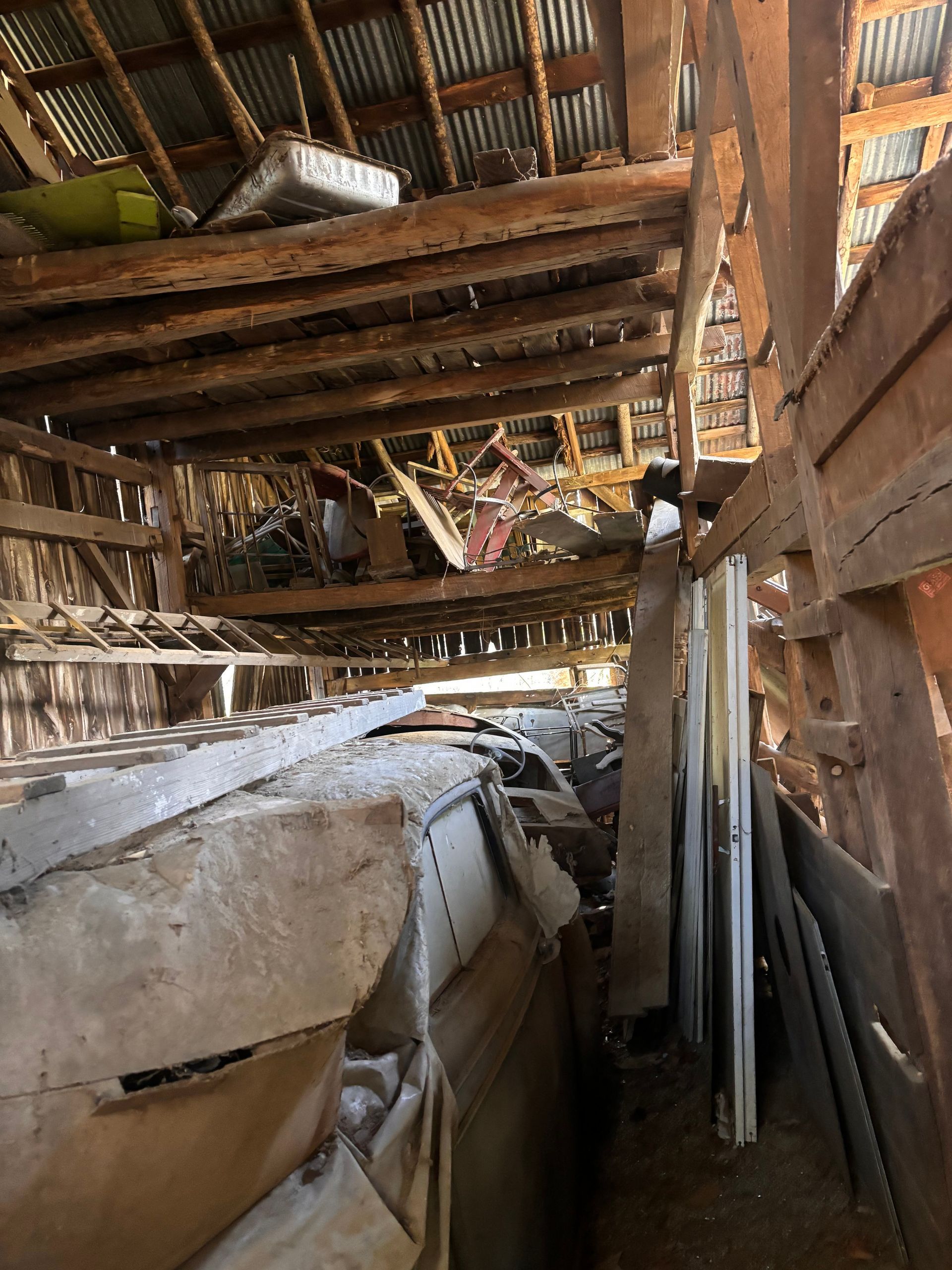 The inside of a wooden building with a lot of wood and boxes.