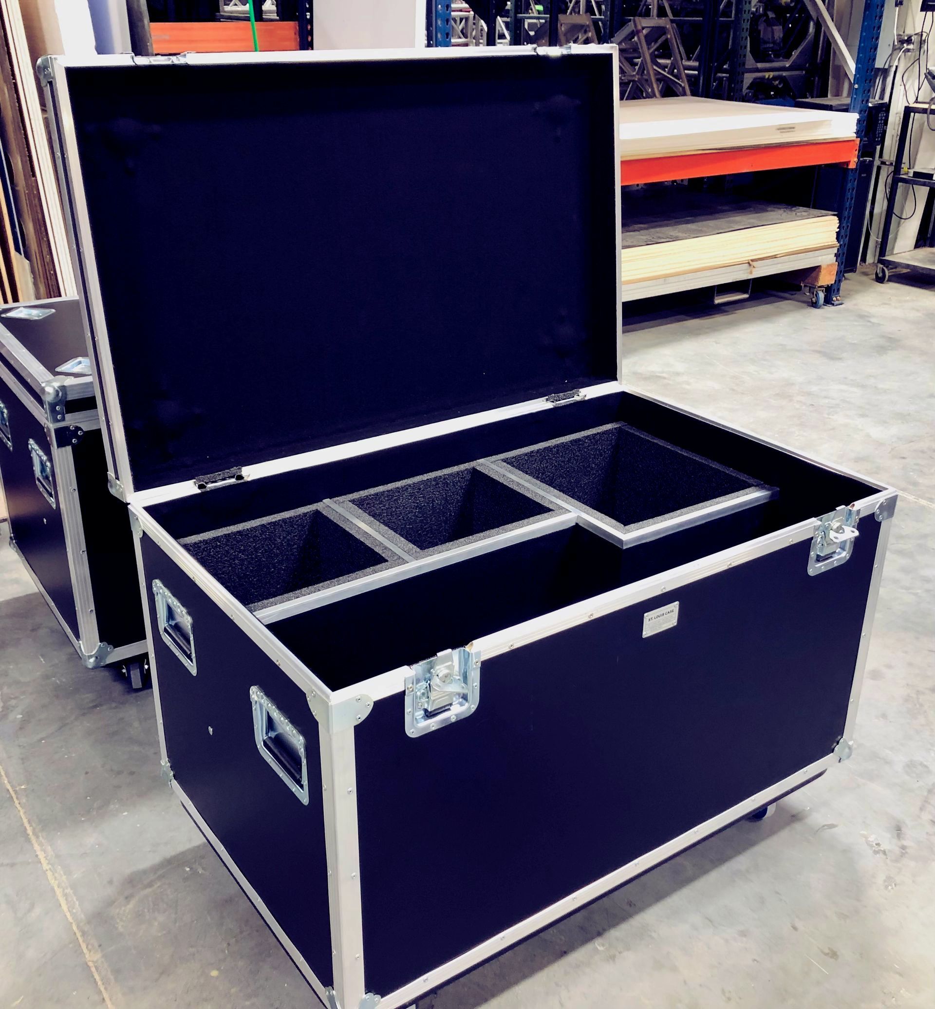 Black road case with an open lid, containing compartments.