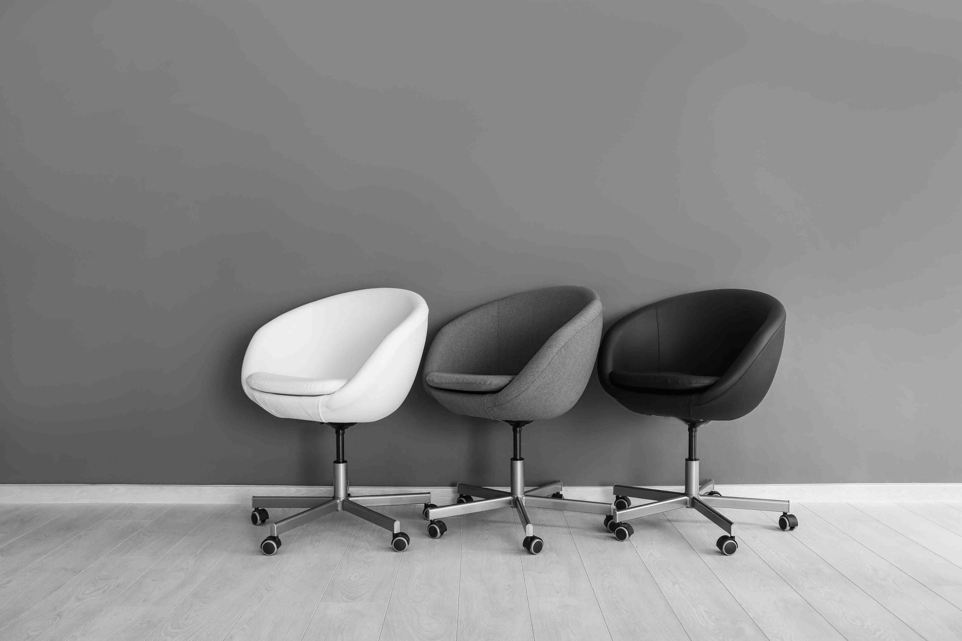 A depiction of a grey color scheme in a room with grey flooring and also office chairs with grey tones