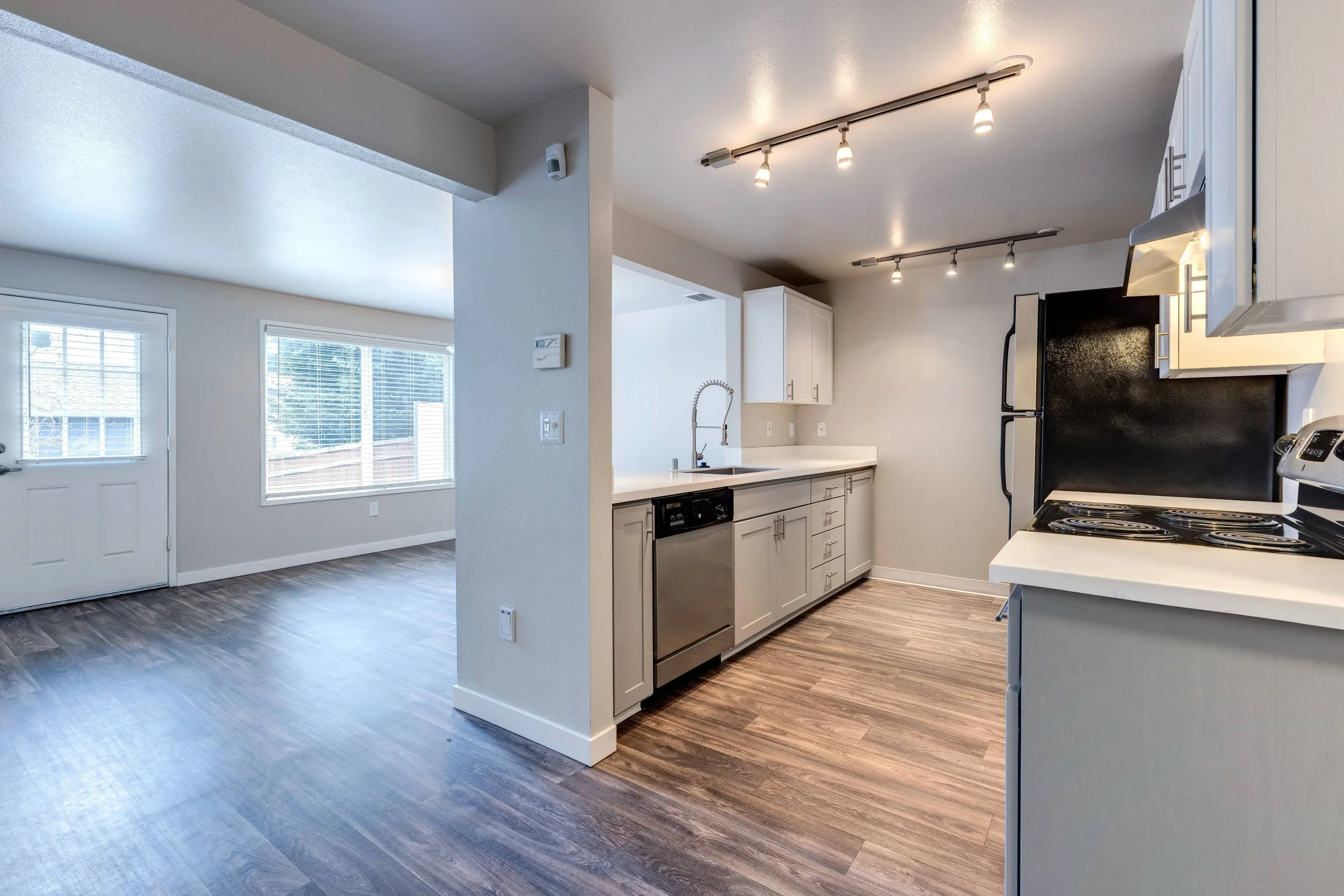 Open-concept kitchen with stainless-steel appliances and a large sink.