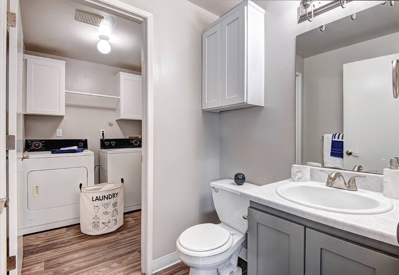 Bathroom with sink, vanity, and mirror; adjacent laundry area with washer and dryer.