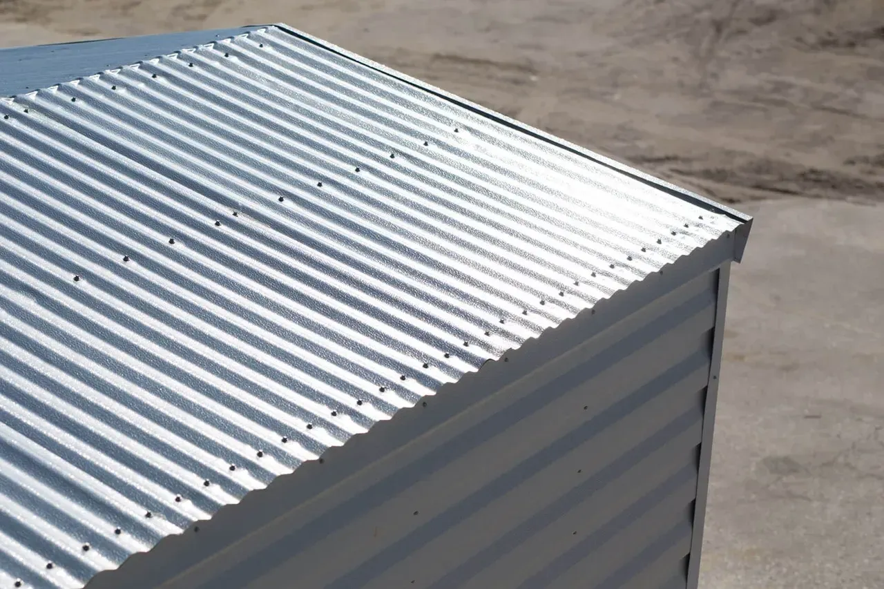 Corrugated metal roof on a light-colored building, viewed from above.
