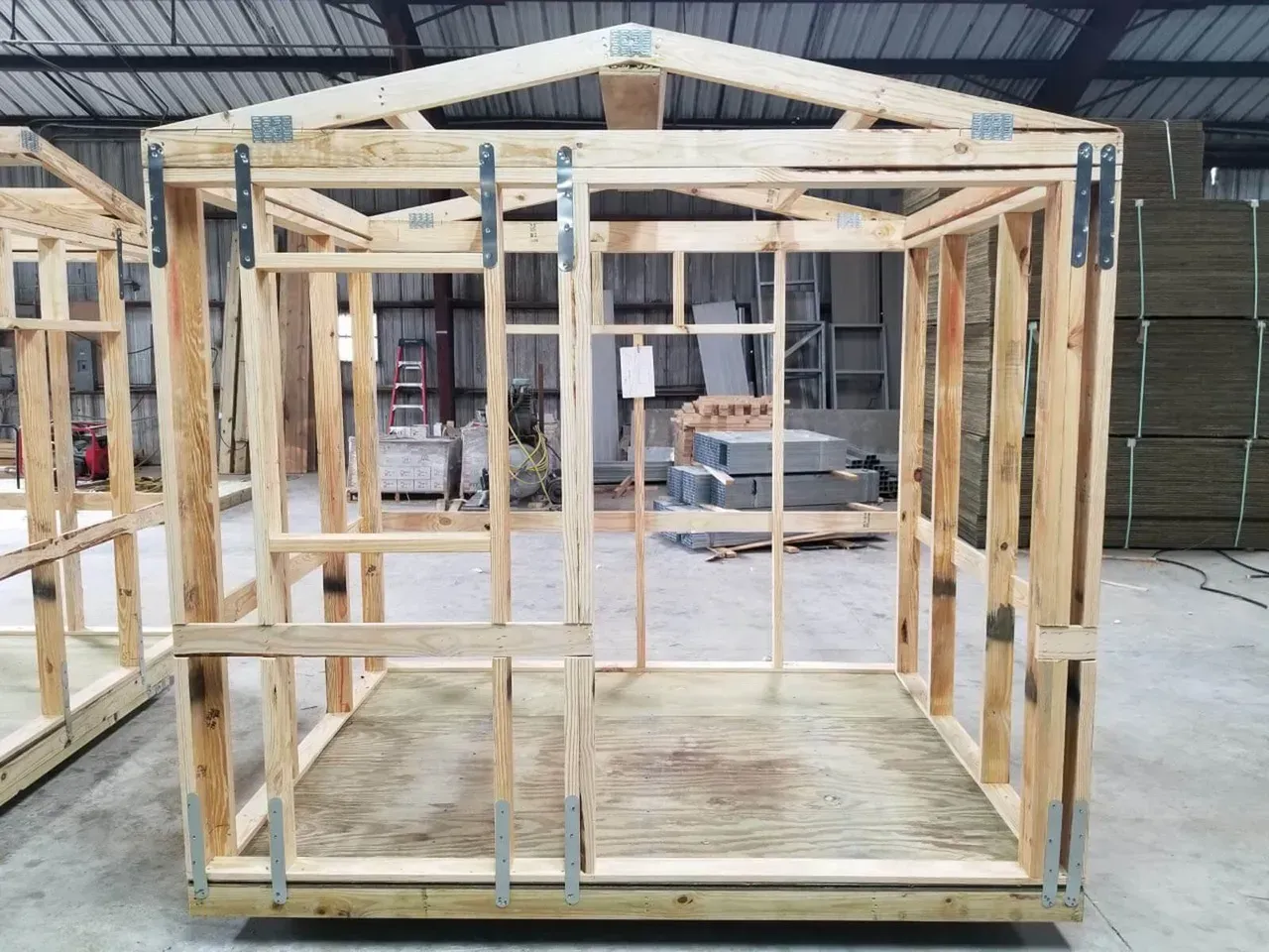 Wooden shed frame with door and window openings, ready for siding and roofing.