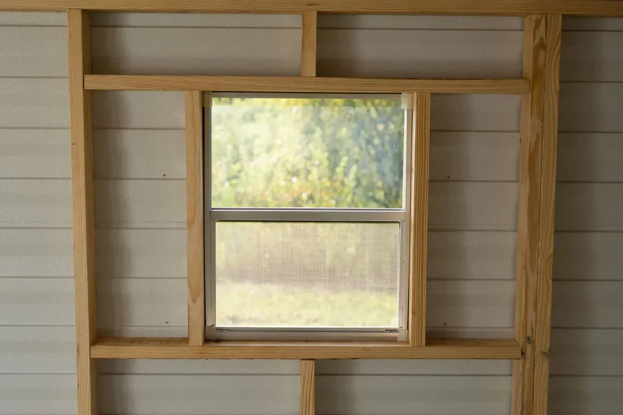 Wooden window frame with an installed window; interior view, daylight.