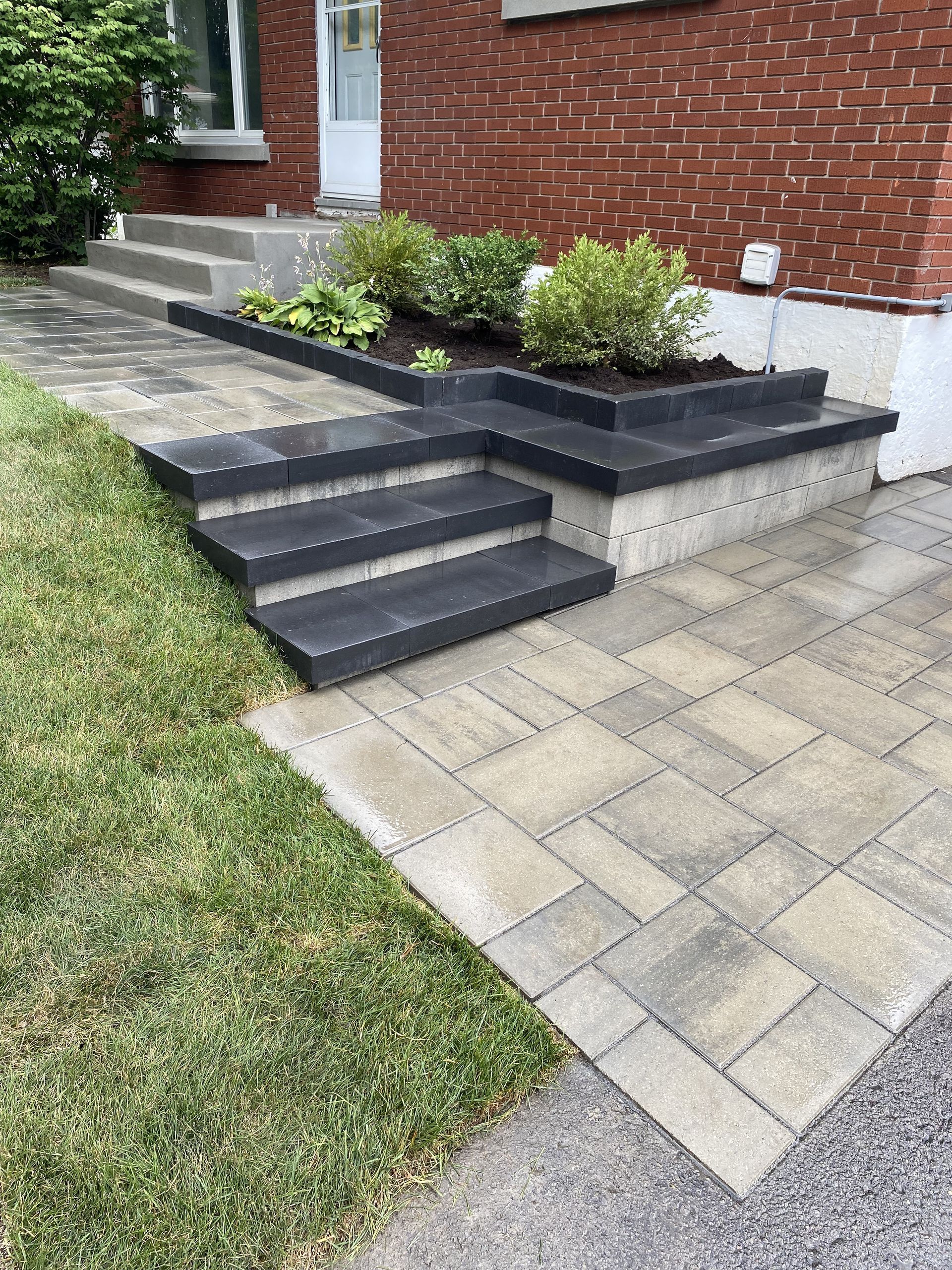 a brick building with steps and a planter in front of it