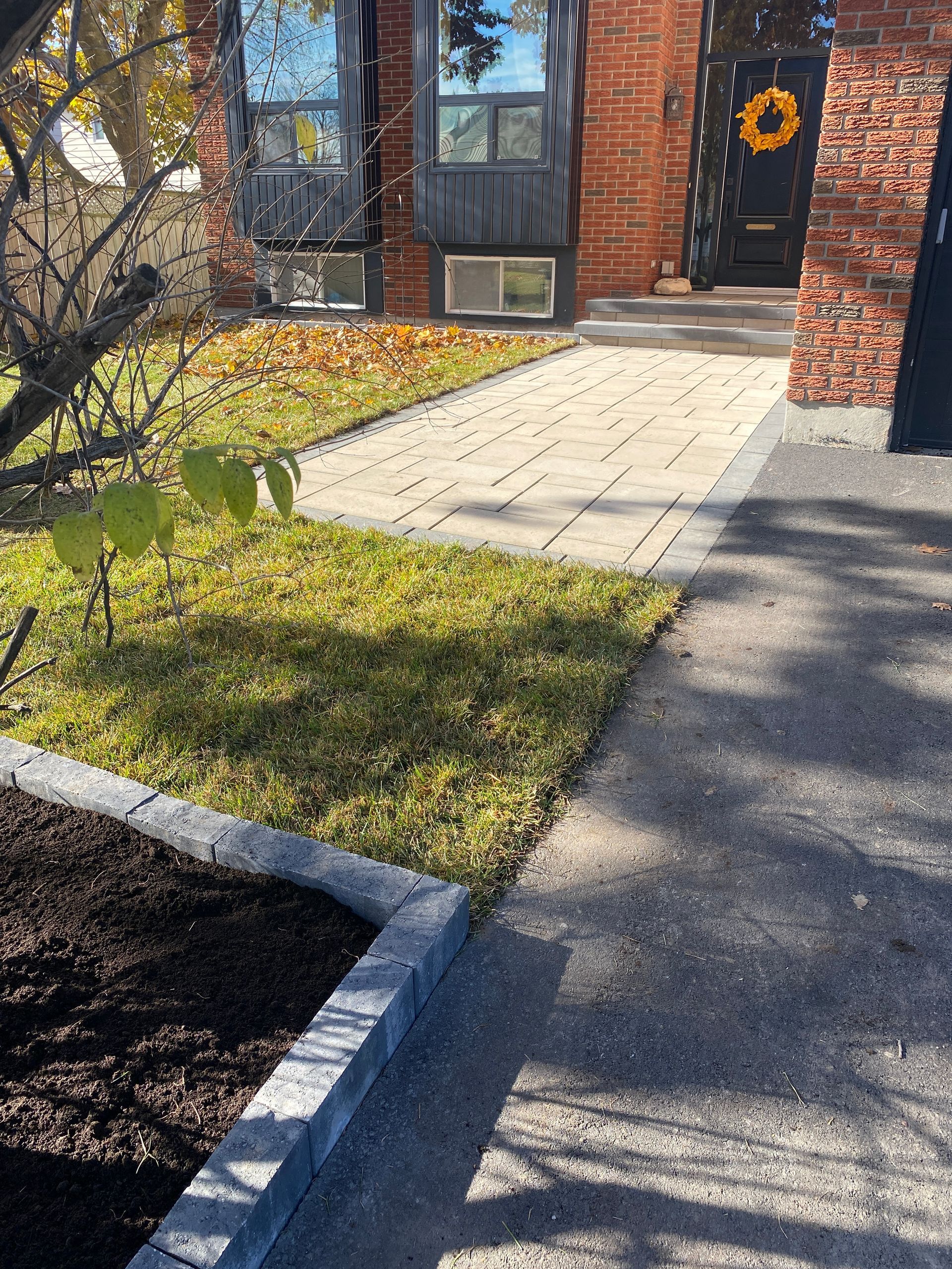 a brick house with a wreath on the front door and a walkway