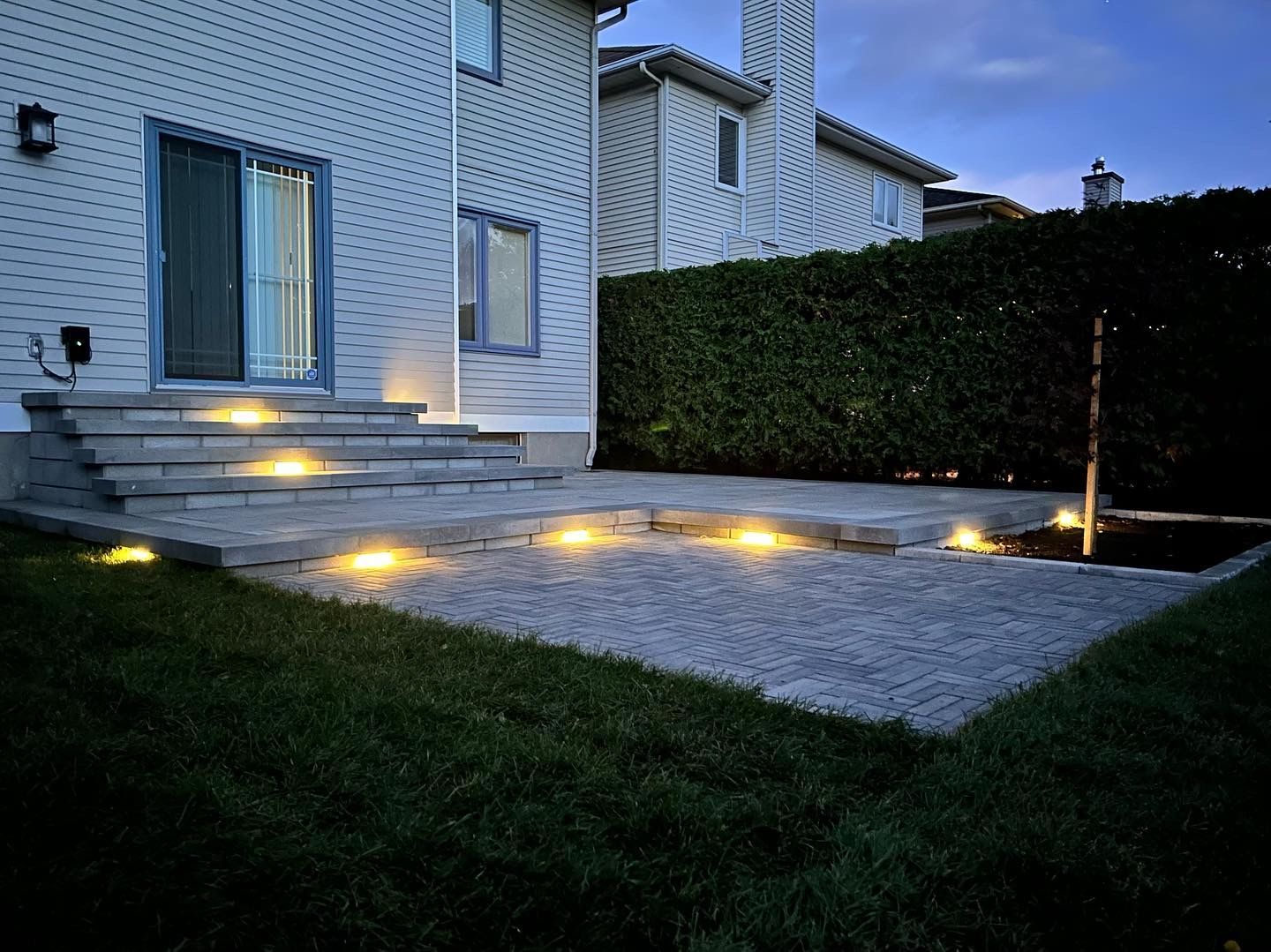 the backyard of a house is lit up at night