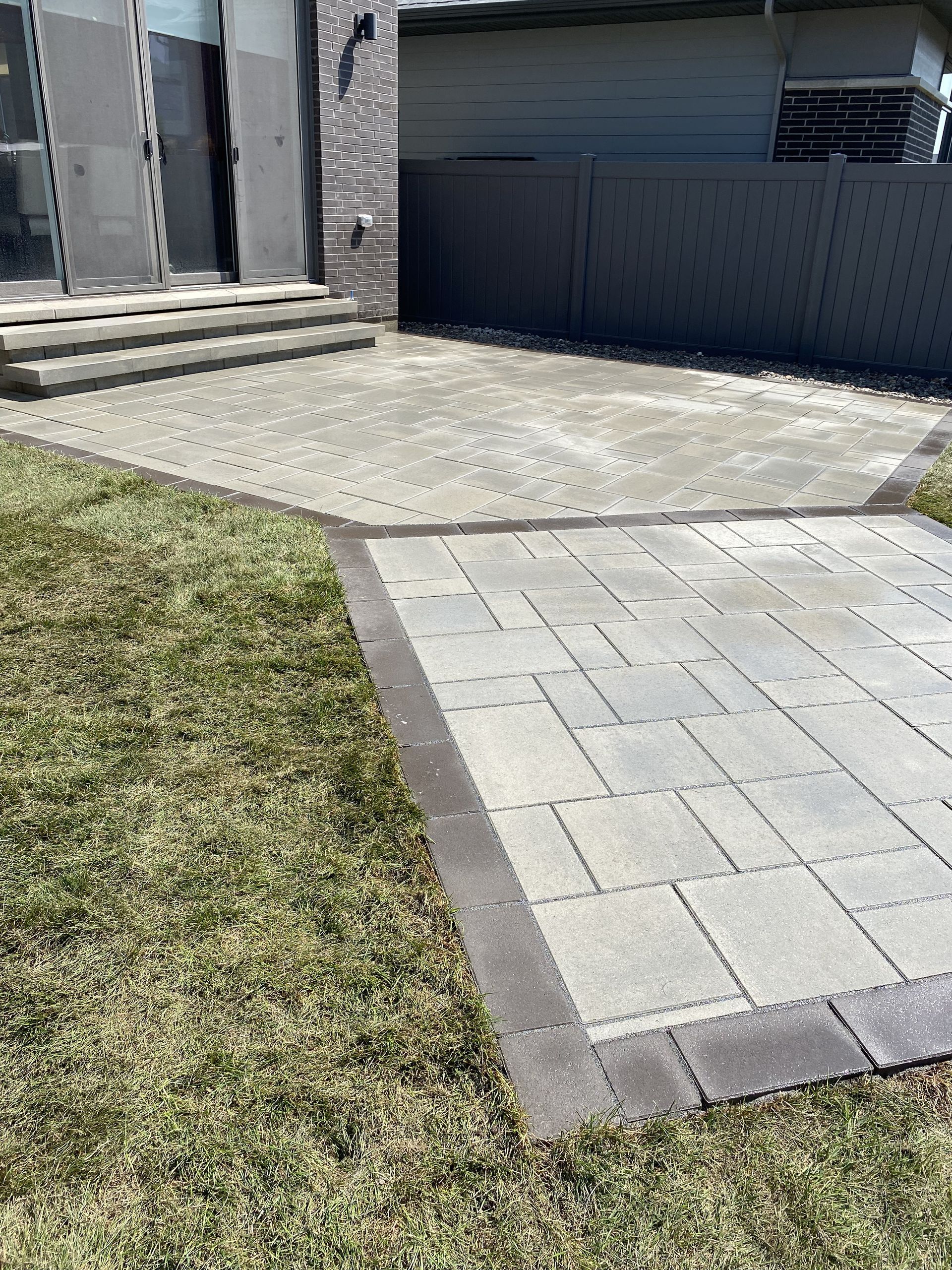 a patio with a gray fence in the background