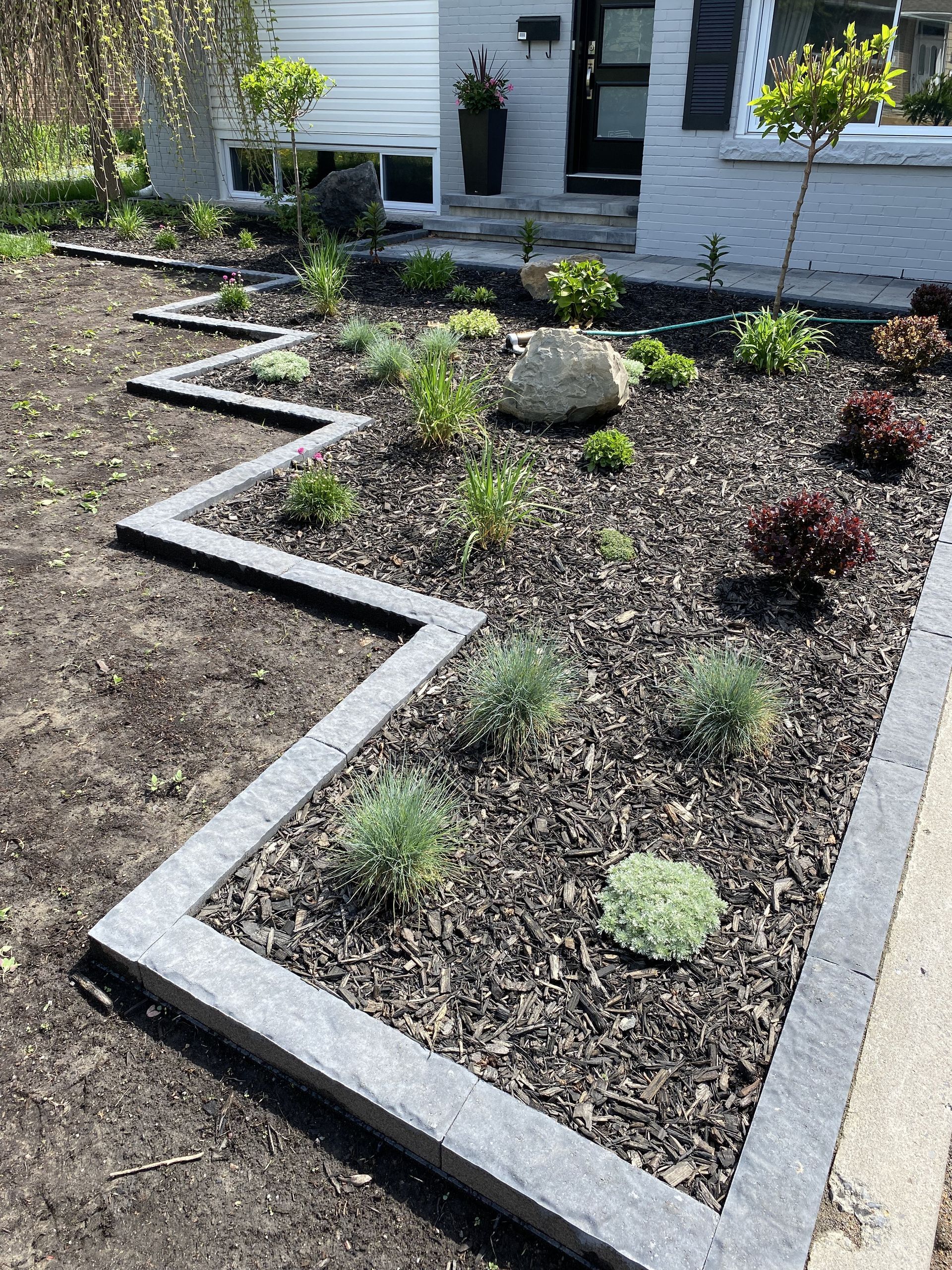 a garden with a rock in the middle of it