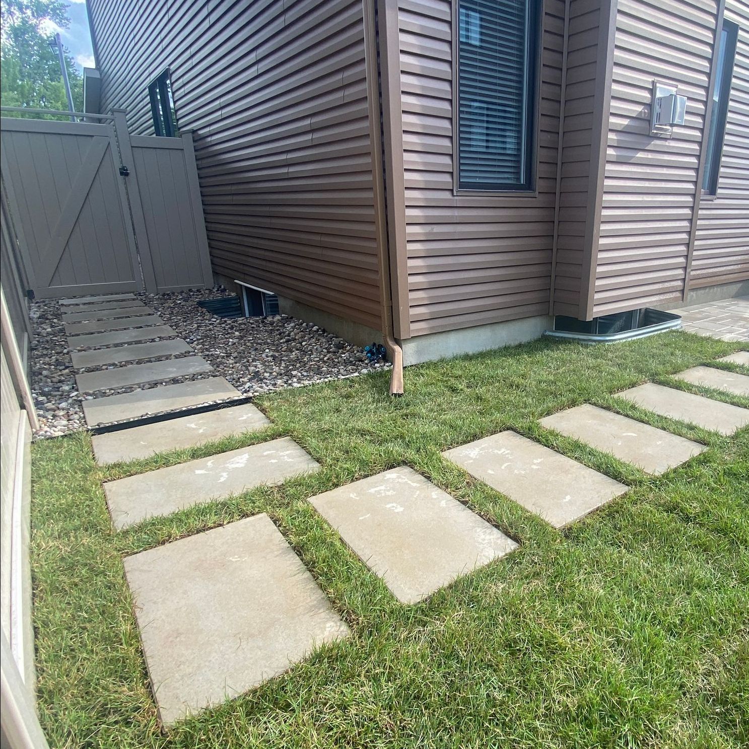 a house with a walkway in front of it and a gate .