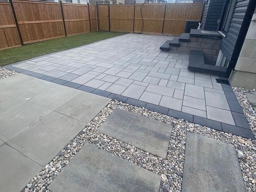 a patio with steps and a wooden fence in the backyard of a house