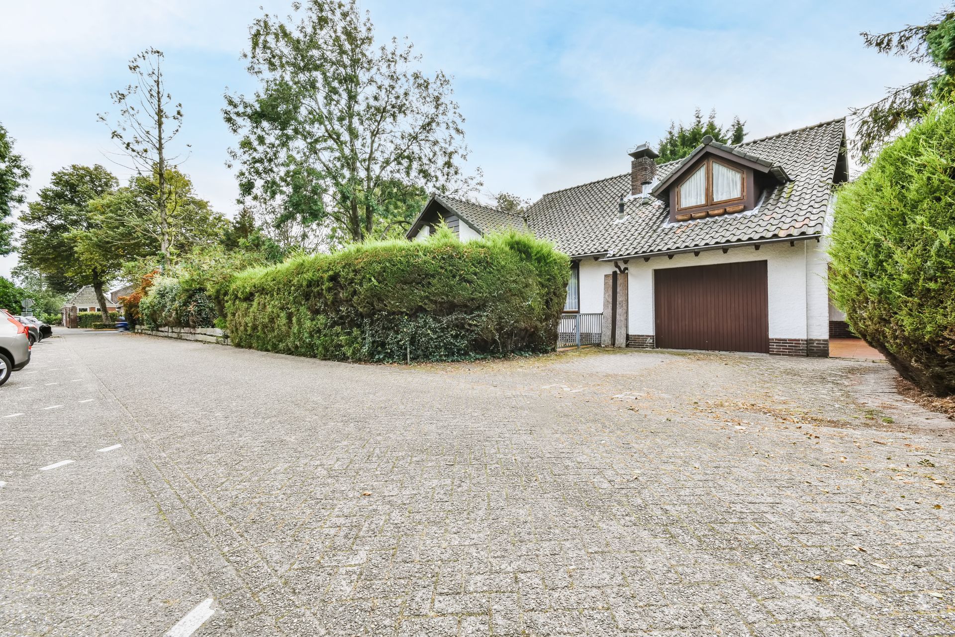 A car is parked in front of a house with a garage