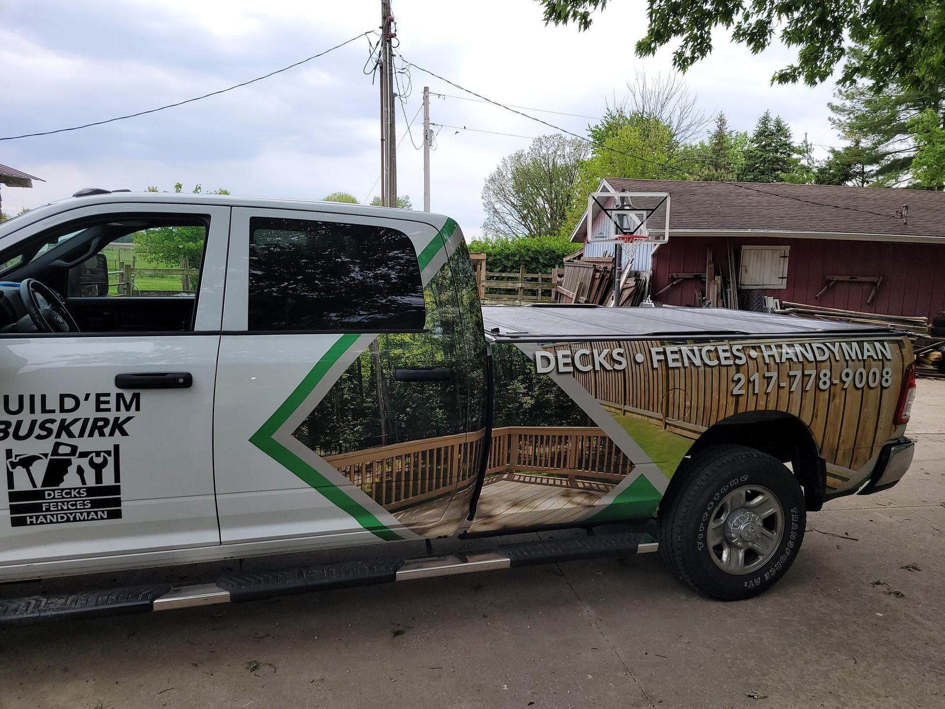 White pickup truck with landscaping business graphics and green arrow design parked outdoors