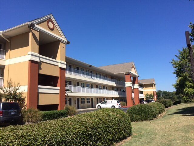A large apartment building with cars parked in front of it