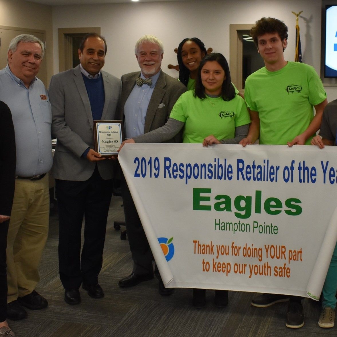 A group of people holding a sign that says 2019 responsible retailer of the year eagles