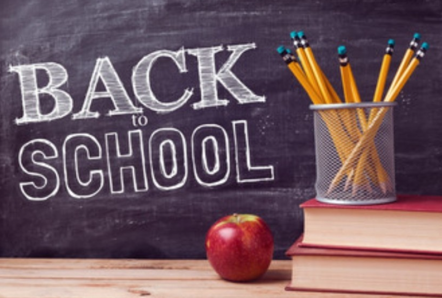 Back to School written on a chalk board with books, an apple, and a basket of pencils