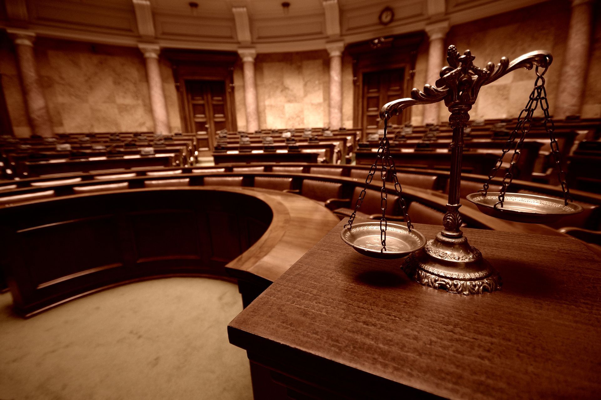 Empty courtroom with wooden benches, judge’s bench, and scales of justice in warm sepia tones. Empty courtroom with wooden benches, judge’s bench, and scales of justice in warm sepia tones.
