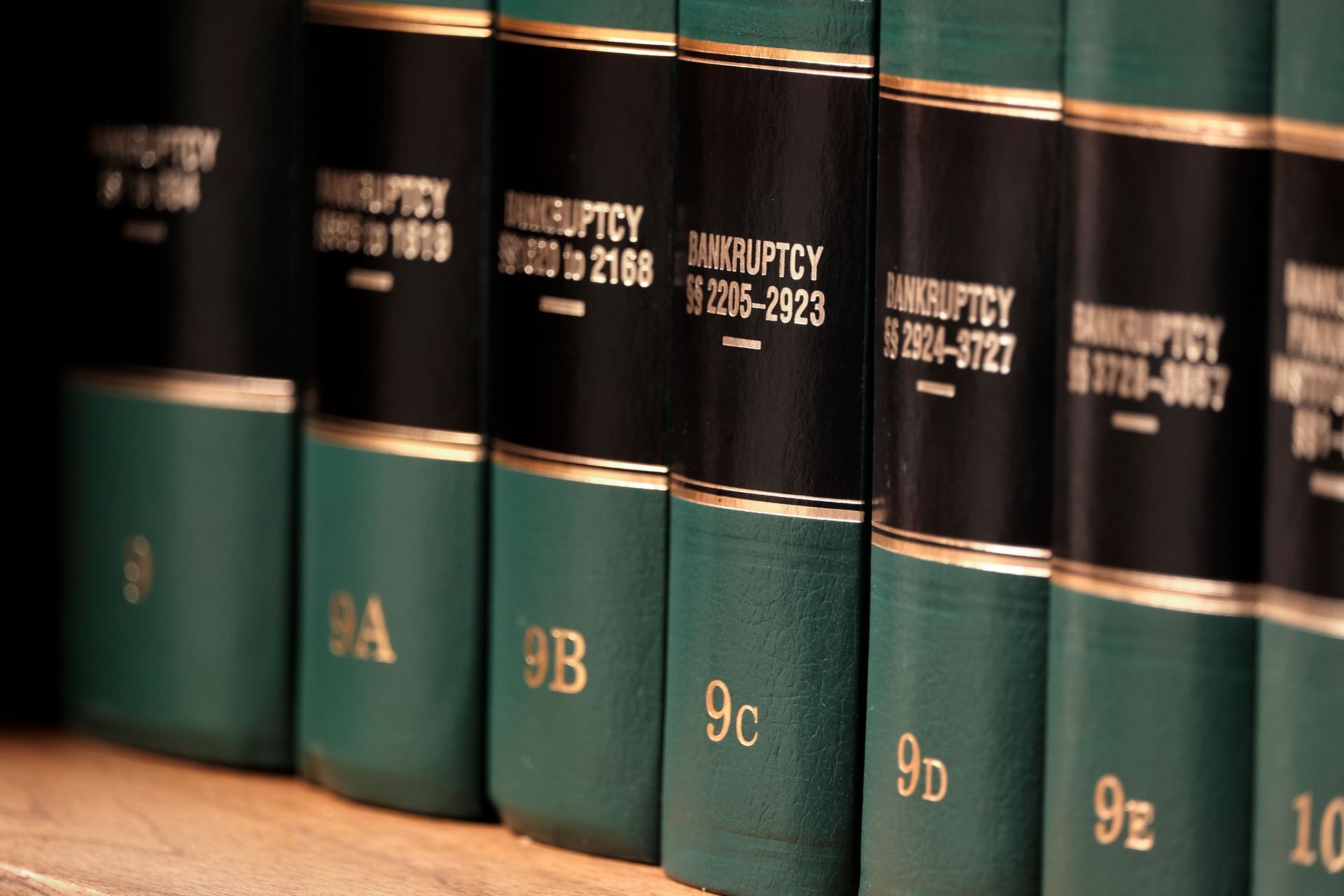 Row of green-and-black law books on a wooden shelf, labeled with gold spine text. Row of green-and-black law books on a wooden shelf, labeled with gold spine text.