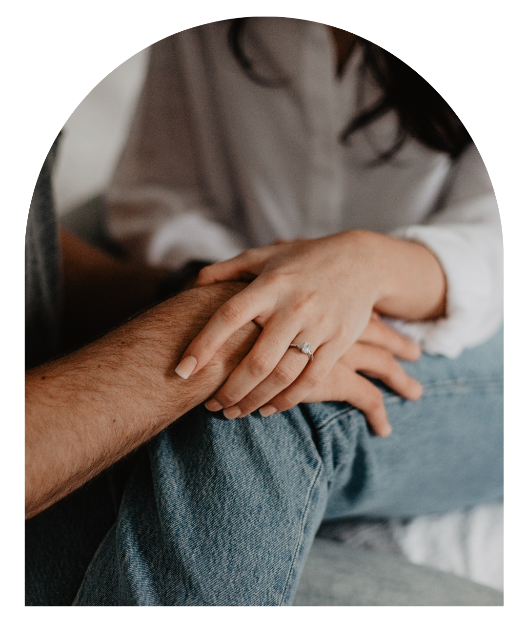 A woman wearing a wedding ring is holding a man 's hand.