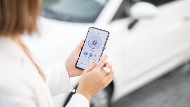 Persoon met smartphone in de hand gebruikt app om een ​​auto te ontgrendelen.