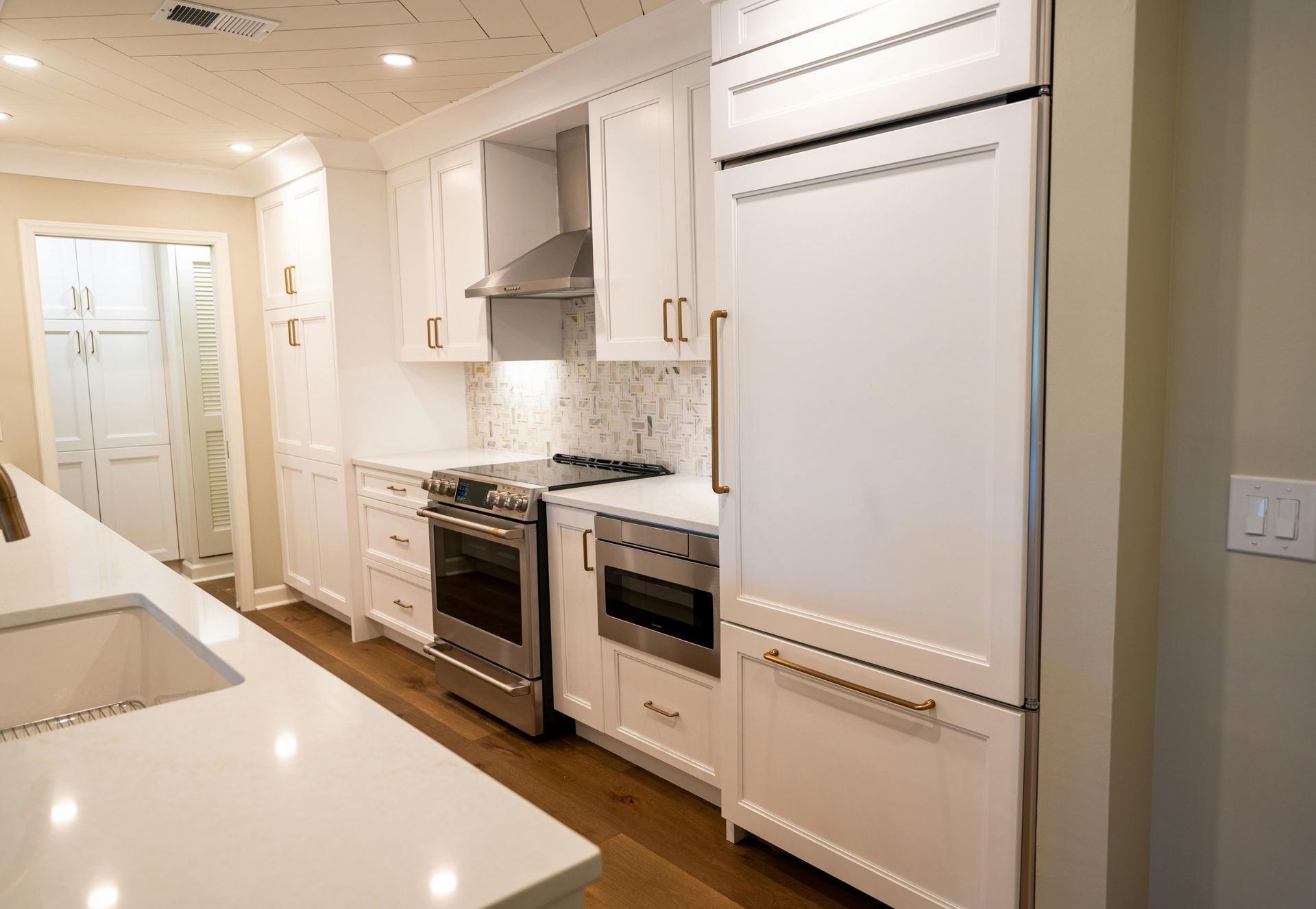 Bright modern kitchen with white cabinets, stainless appliances, and a large island countertop