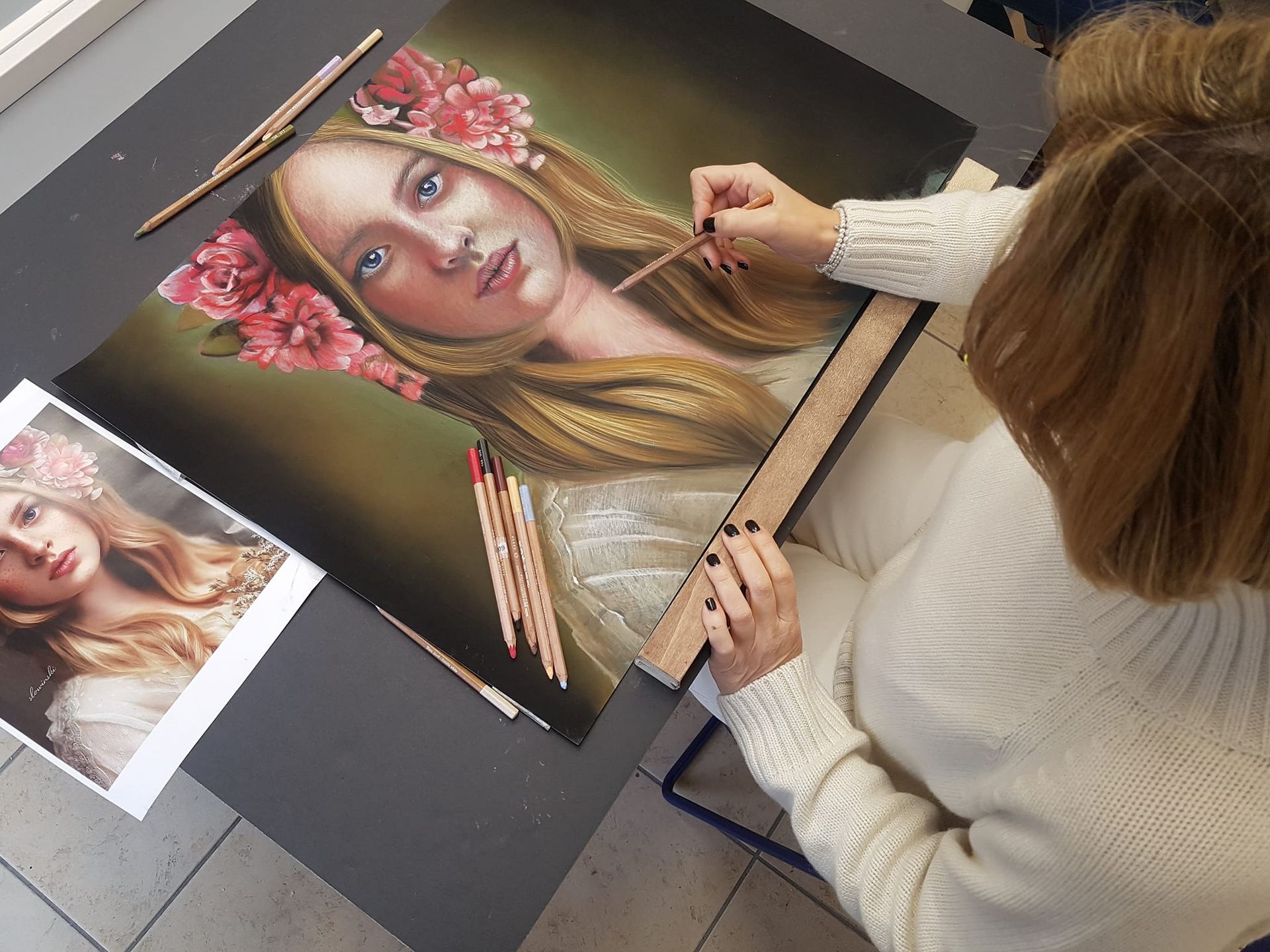 Una donna sta dipingendo un'immagine di una donna con fiori tra i capelli
