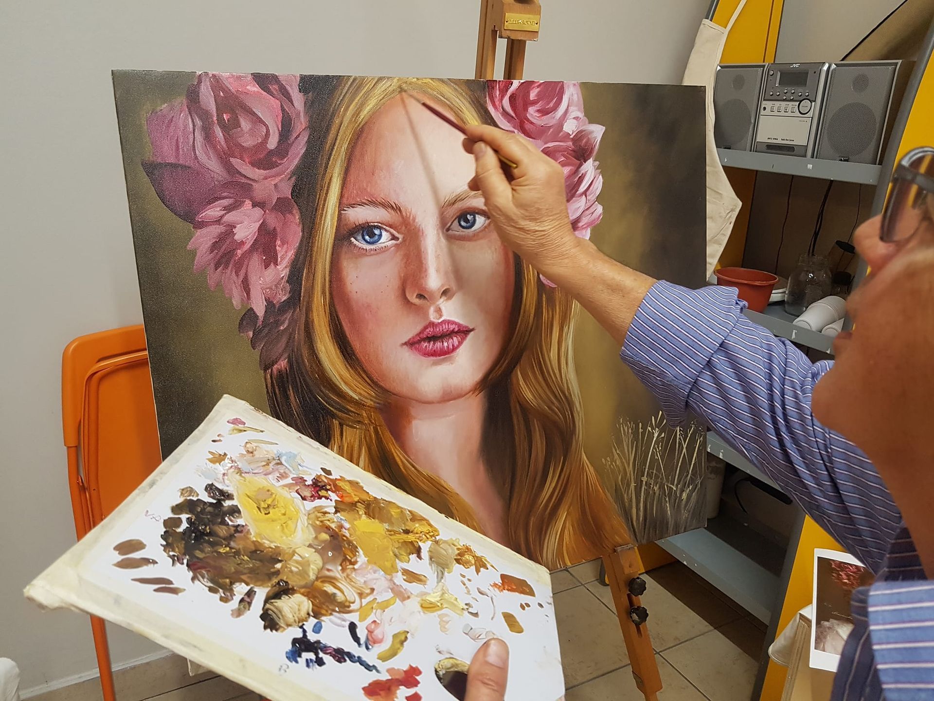 Un uomo sta dipingendo l'immagine di una donna con fiori tra i capelli.