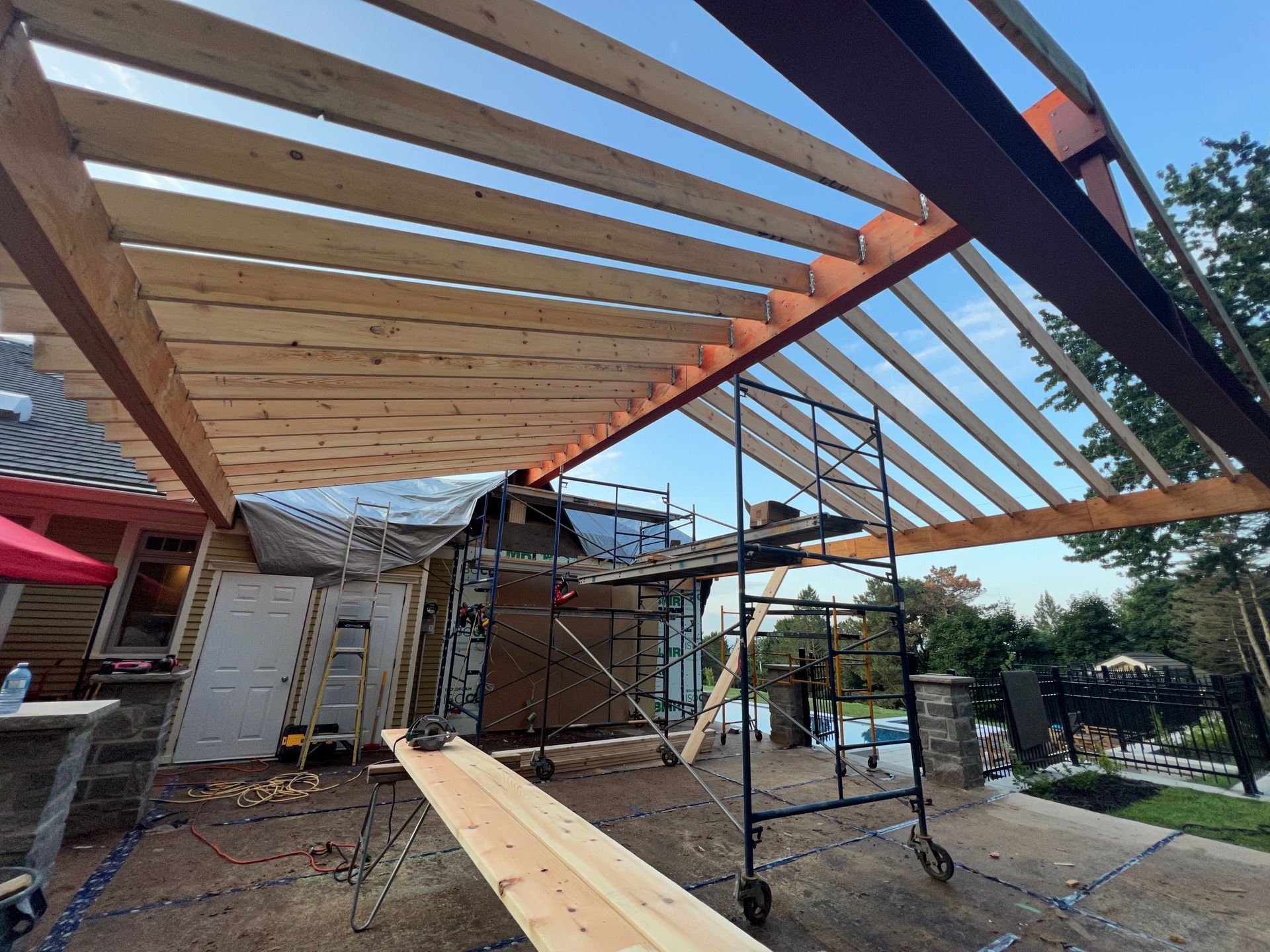 Une structure en bois est en cours de construction au sommet d'une maison.