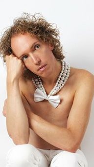 Gerald Drent, met krullend haar, zingt in de Pride Show van Nederlied in Theater Het Zonnehuis in Amsterdam.