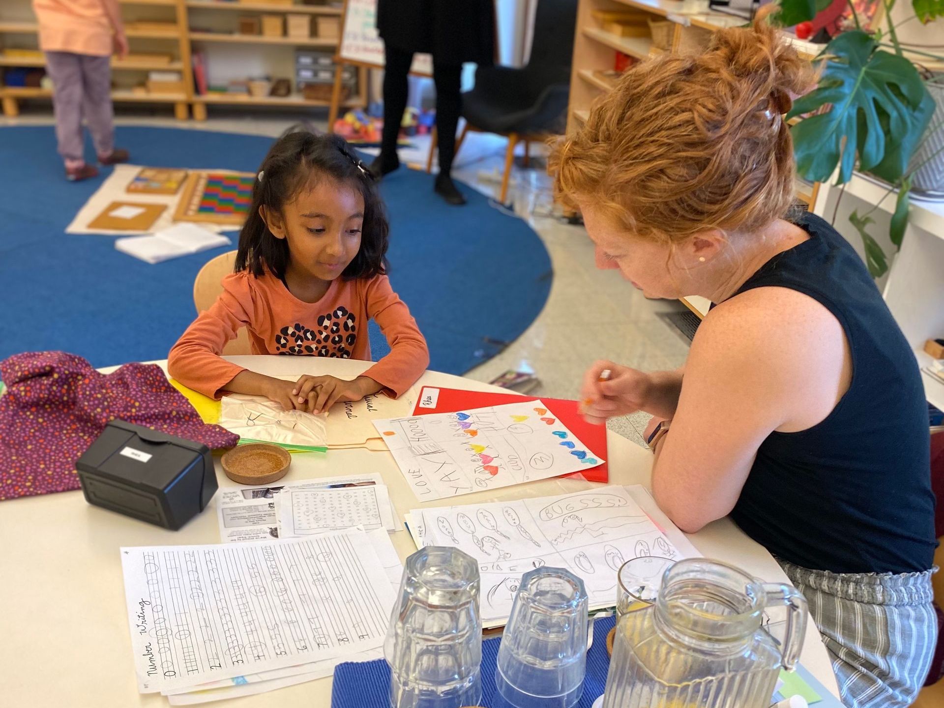 An Elementary student at Chesterfield Montessori meeting with their teacher. Students are being empowered in their Montessori environment at CMS to think critically, advocate for themselves, and have meaningful, productive conversations with peers and adults.