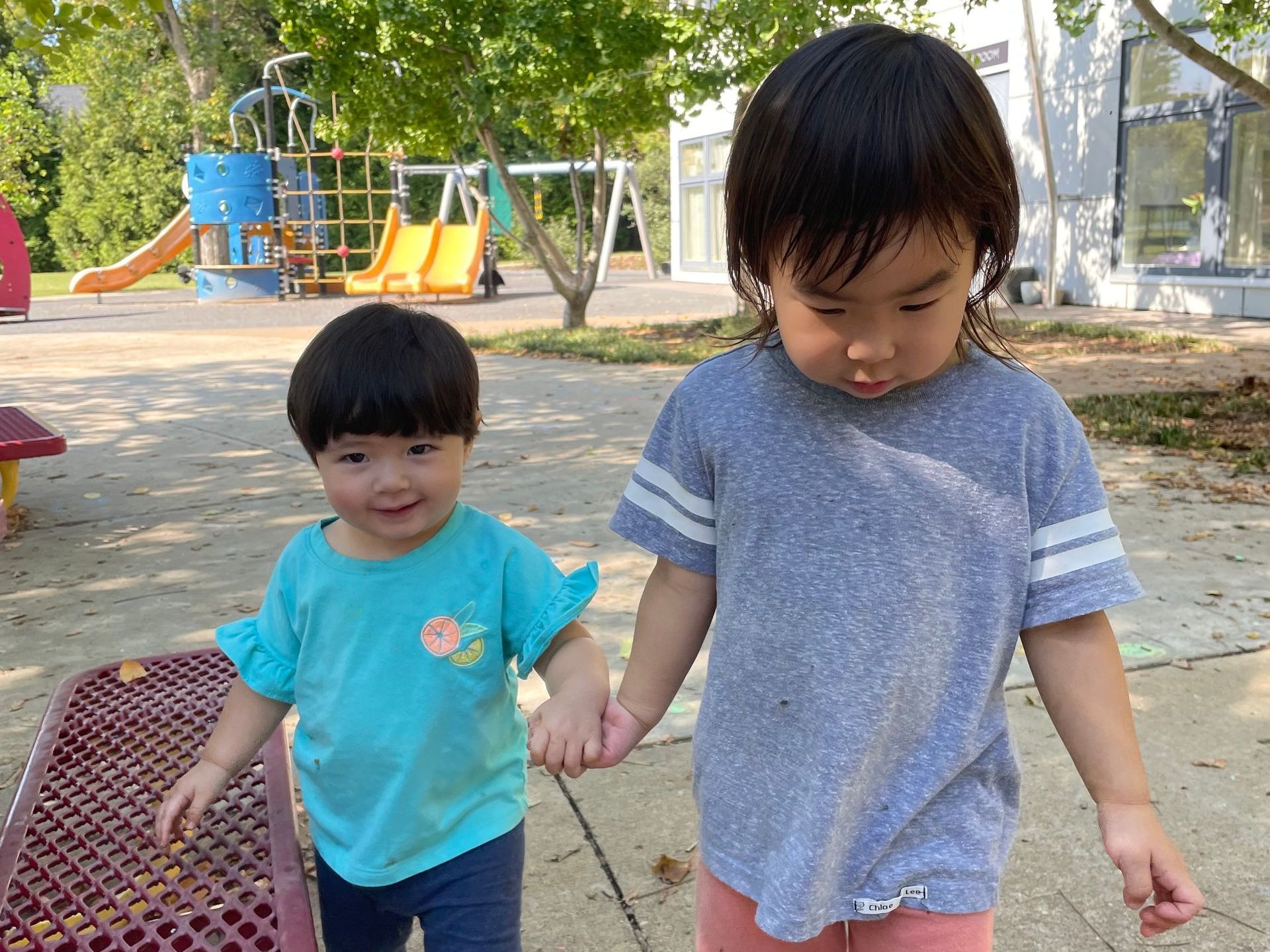 Two young children holding hands.