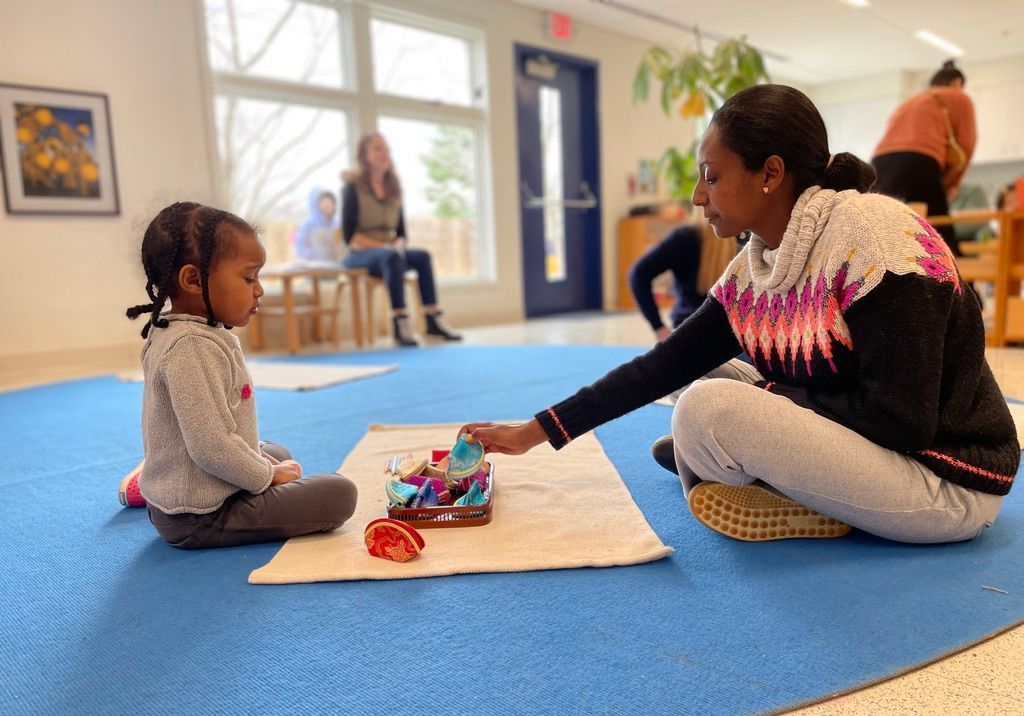 Parent and their Montessori child learning a lesson together.