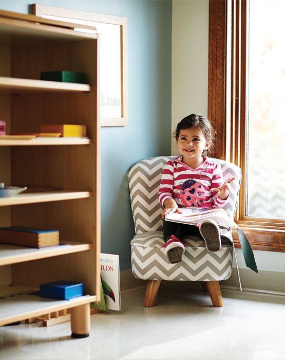 Montessori child reading and smiling.