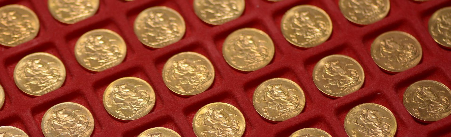 Stack of gold bullion bars representing investment-grade precious metals in auction