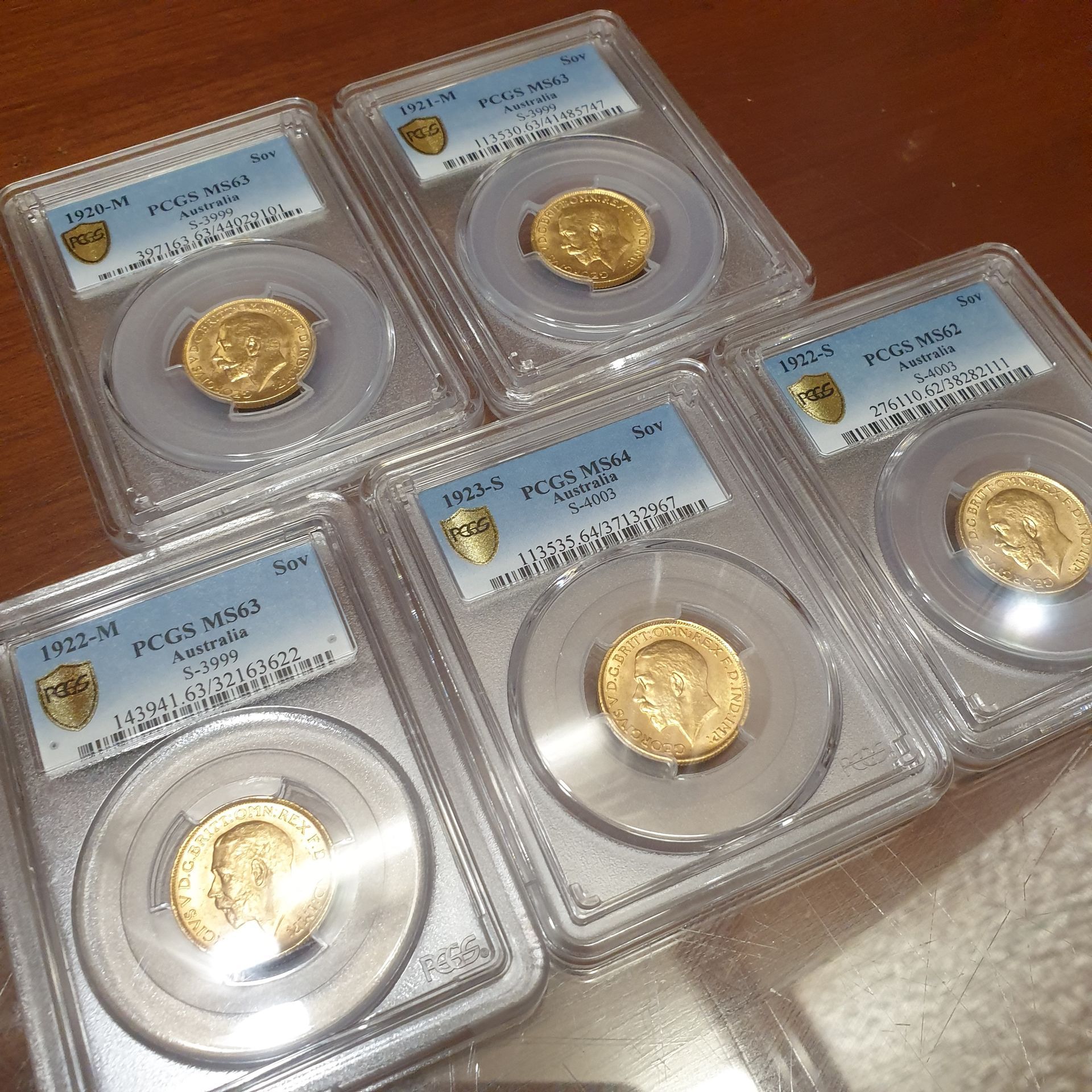 Group of Australian gold sovereign coins graded by PCGS, displayed in protective cases for auction.