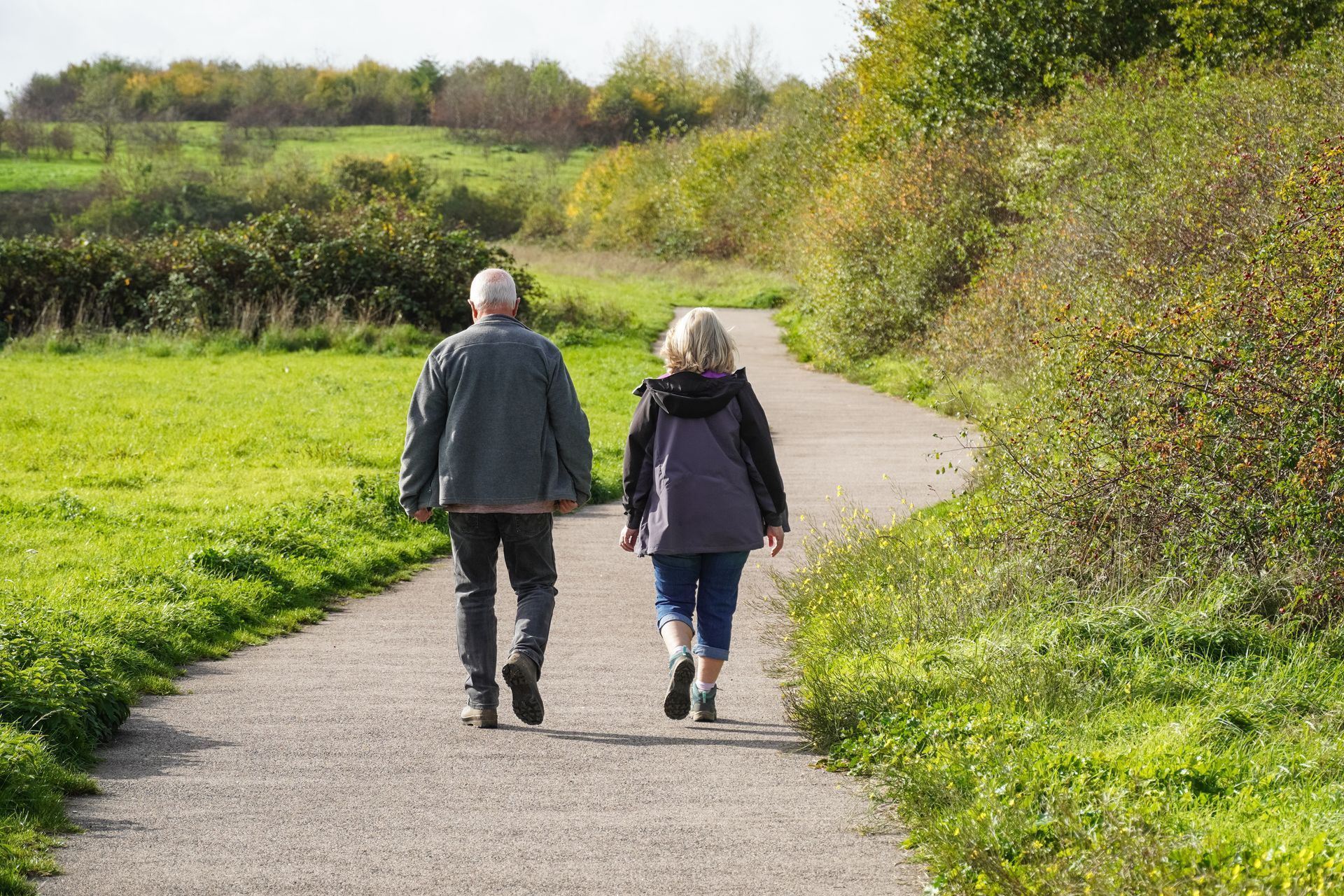 A man and a woman are walking down a path.