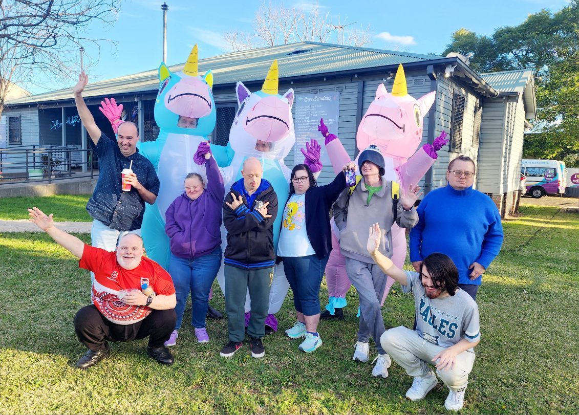 Alive4Life participants and staff having fun outdoors, with three people dressed in inflatable unicorn costumes