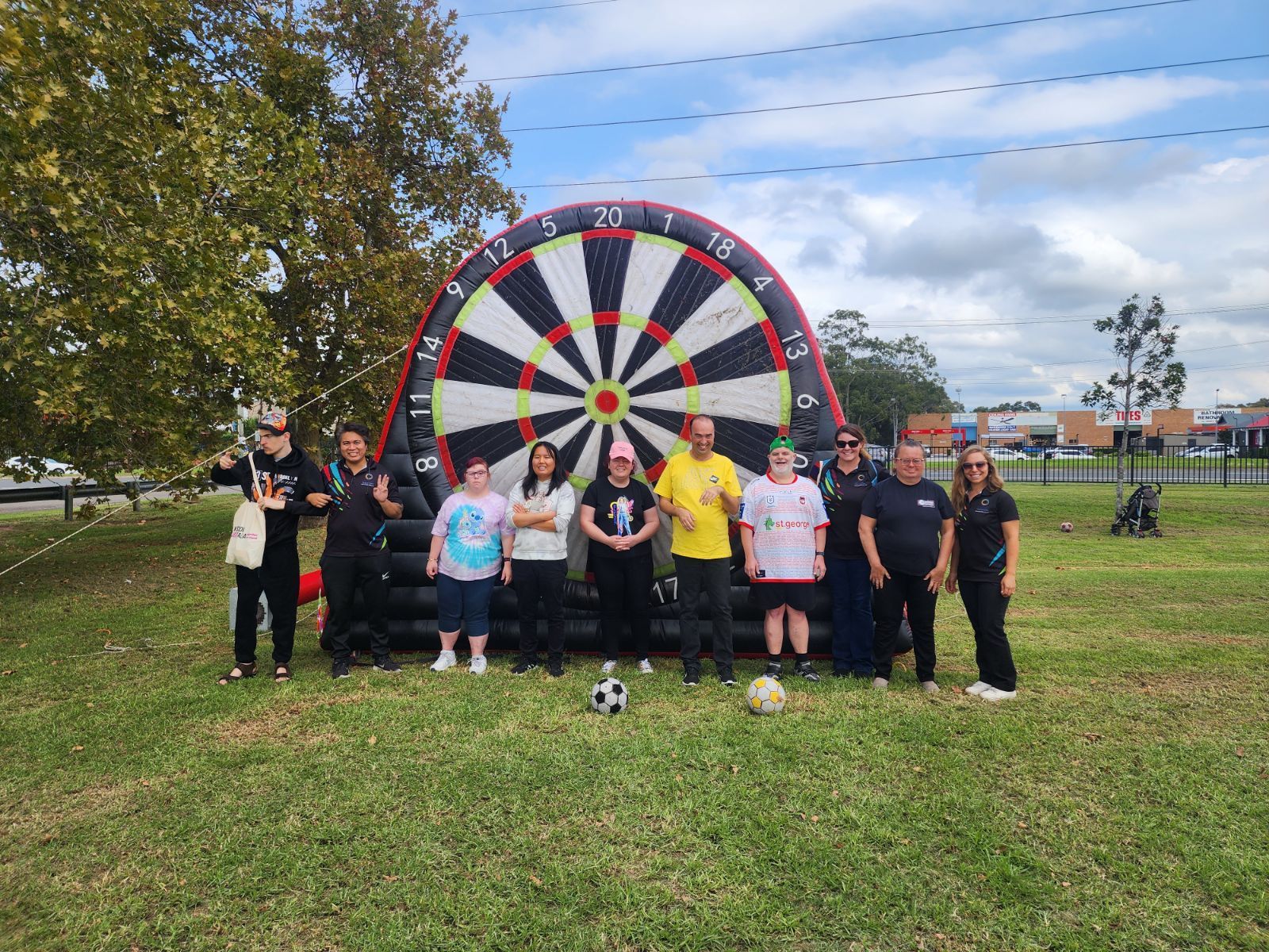 Alive4Life participants and staff playing an outdoor giant soccer darts game in the park