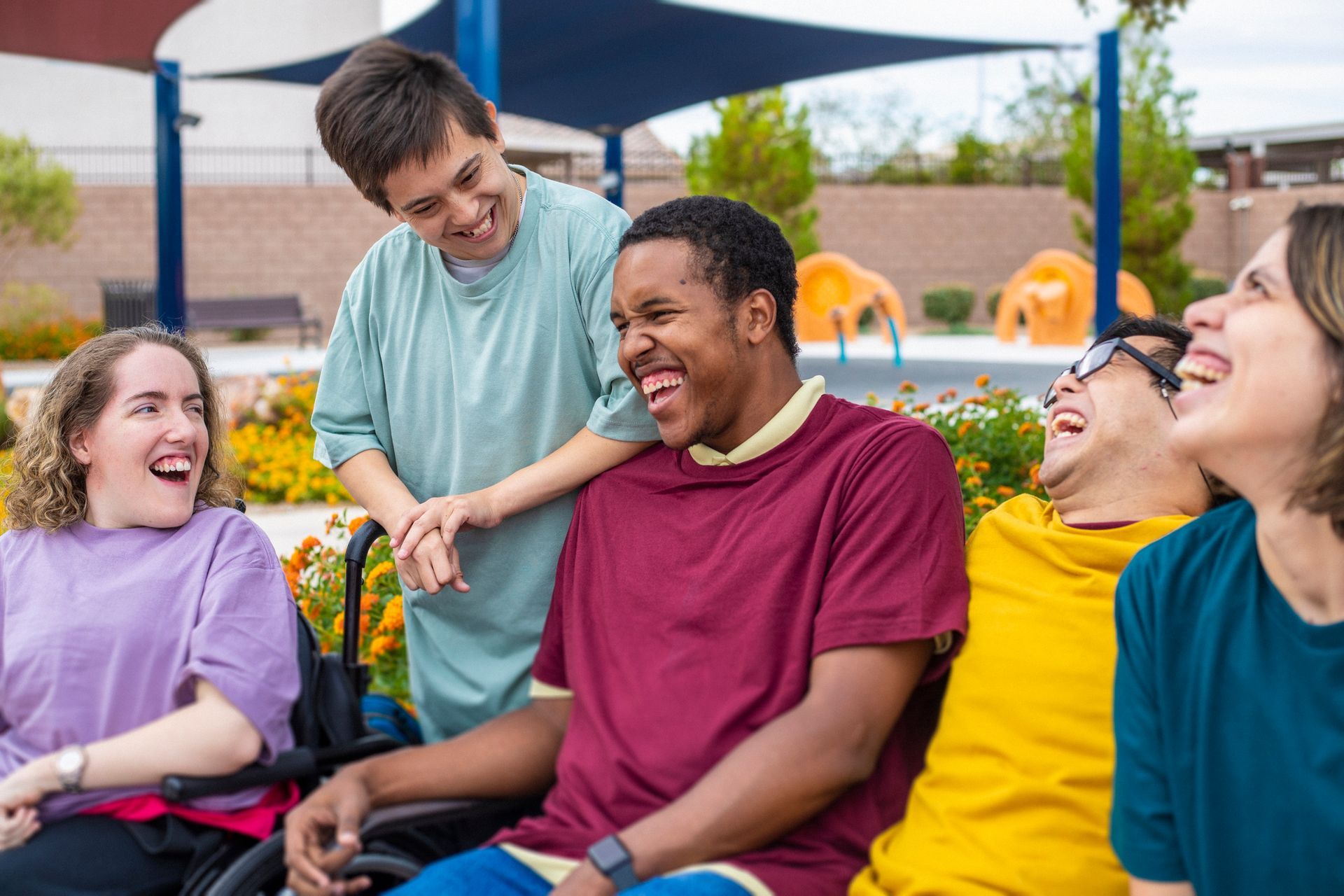 Group of people with disabilities laughing outdoors.
