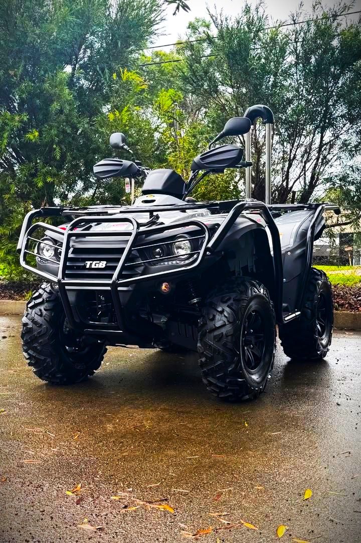 Black ATV Parked on Wet Pavement, Surrounded by Green Trees — MPE Adventure Quads & Bikes In Thornton, NSW