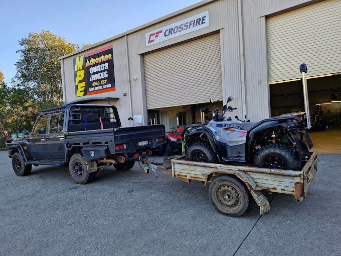 A truck is towing a trailer with an ATV on it — MPE Adventure Quads & Bikes In Singleton, NSW