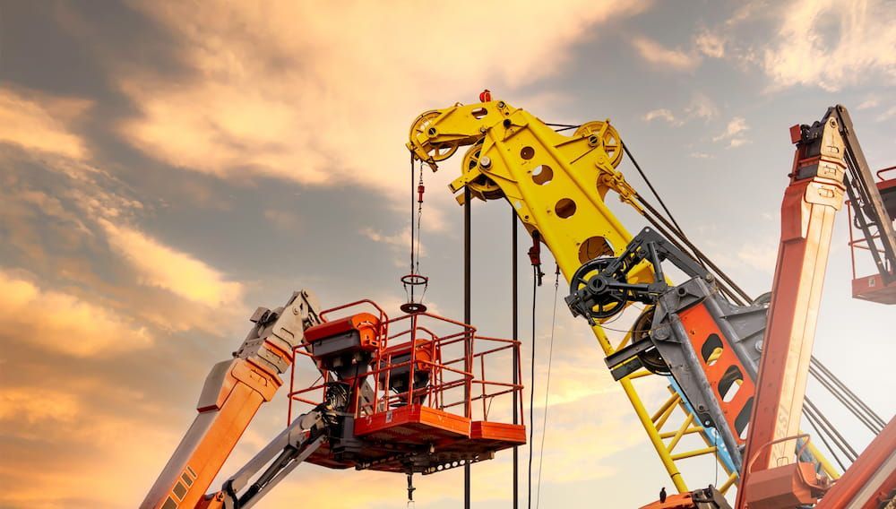 A Couple of Cranes Are Working on a Construction Site — MPE Adventure Quads & Bikes In Newcastle, NSW